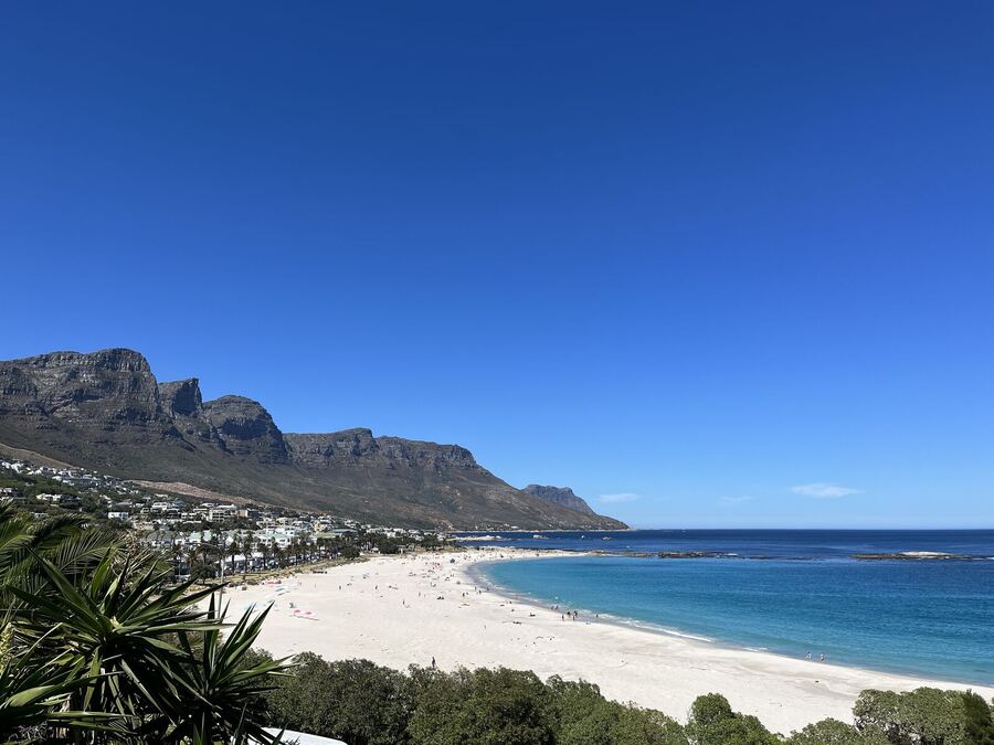 A white beach curving below mountain cliffs and a turquoise sea