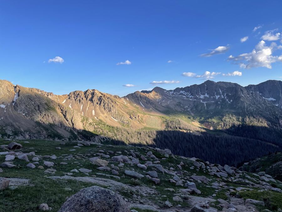 Evening light turning a ridgeline gold while the valley below falls into shadow